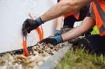 Bild 1: Symbolbild Glasfaser: Zwei Arbeiter bei Kiesschttungen an Gebudewand, Quelle: Deutsche Glasfaser (Verwendung Print und Online honorarfrei)