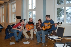 Bild 1: Gemeinsames Gitarrenspiel: Die jungen Arbeitslosen, die über das Regionalbudget zu Erziehern ausgebildet werden, erhalten nun von Studenten der Hochschule Lausitz auch Gitarrenu